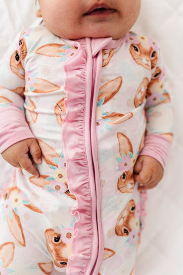 Baby wearing a bunny print bamboo convertible romper with pink trim