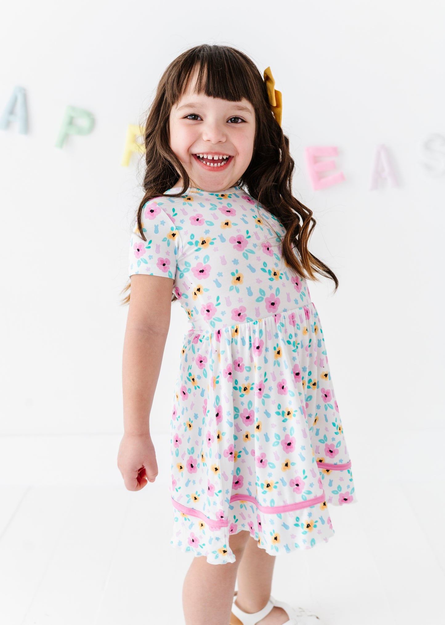 Young girl wearing a bamboo floral PEEPS® dress with a white background
