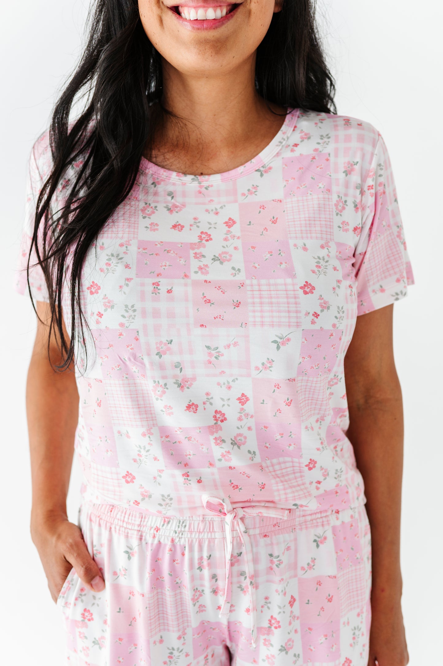 Woman wearing a pink floral patchwork set on a white background