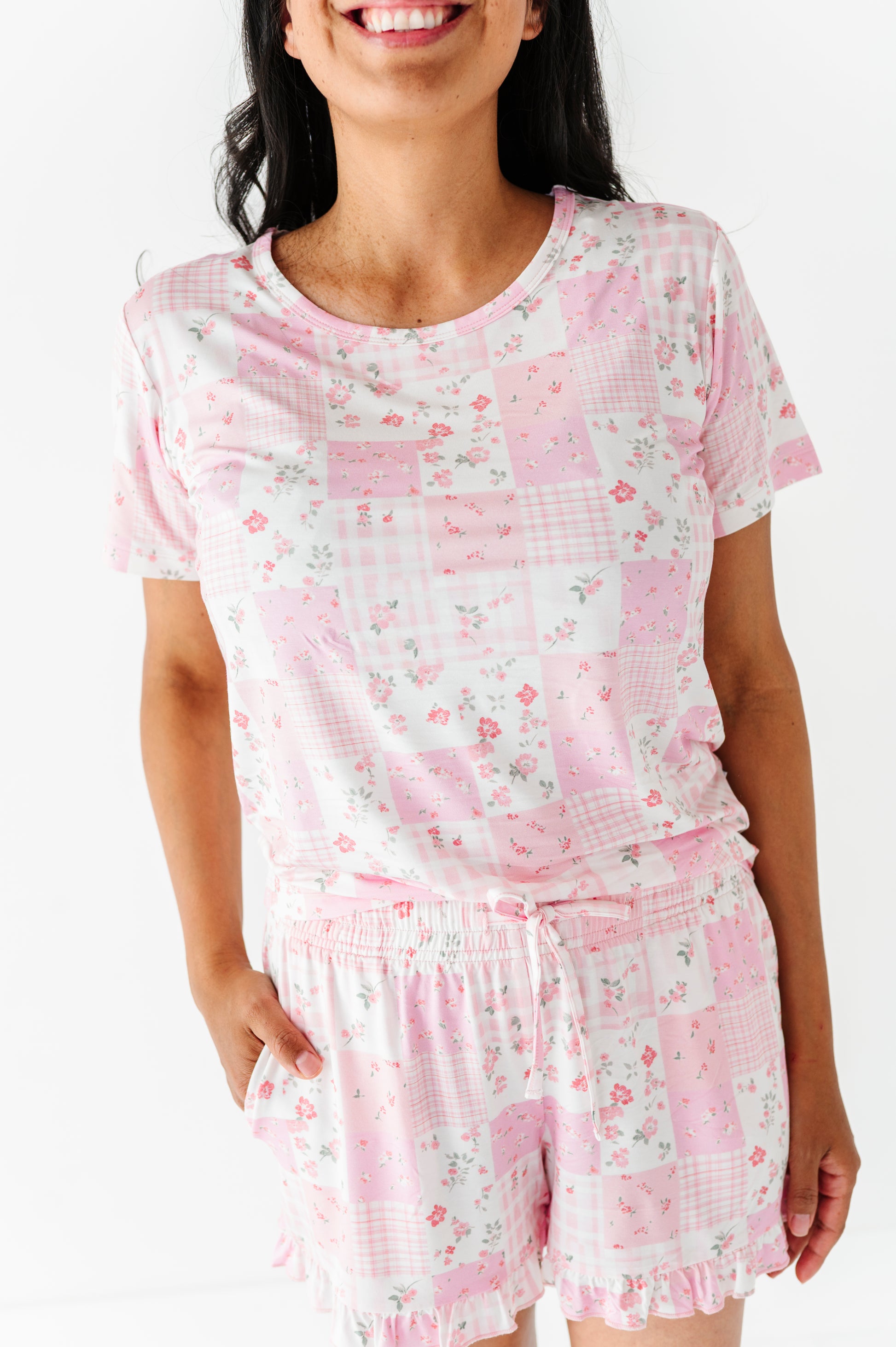 Woman wearing a pink floral pajama set on a white background