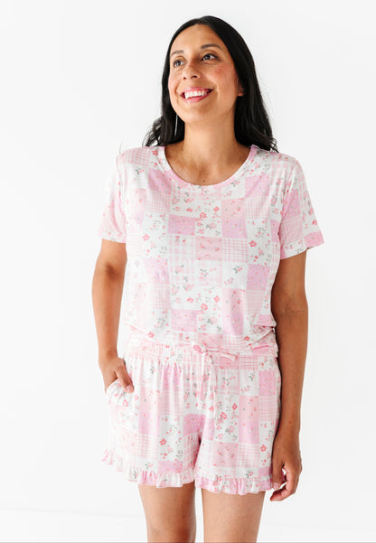 Woman wearing a pink floral pajama set on a white background
