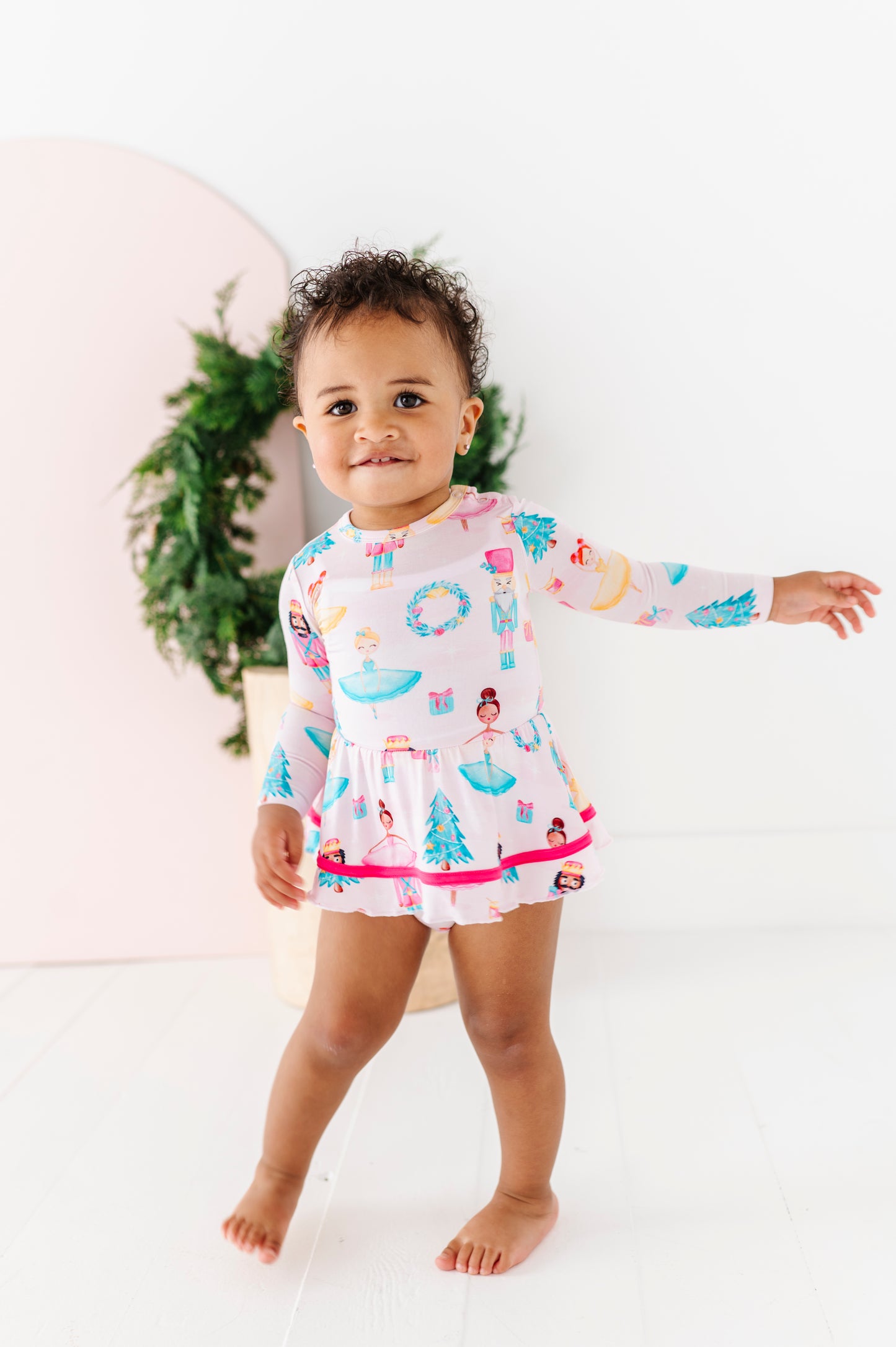 Infant wearing Sugarplum Birdie Twirl bamboo dress with Nutcracker holiday print