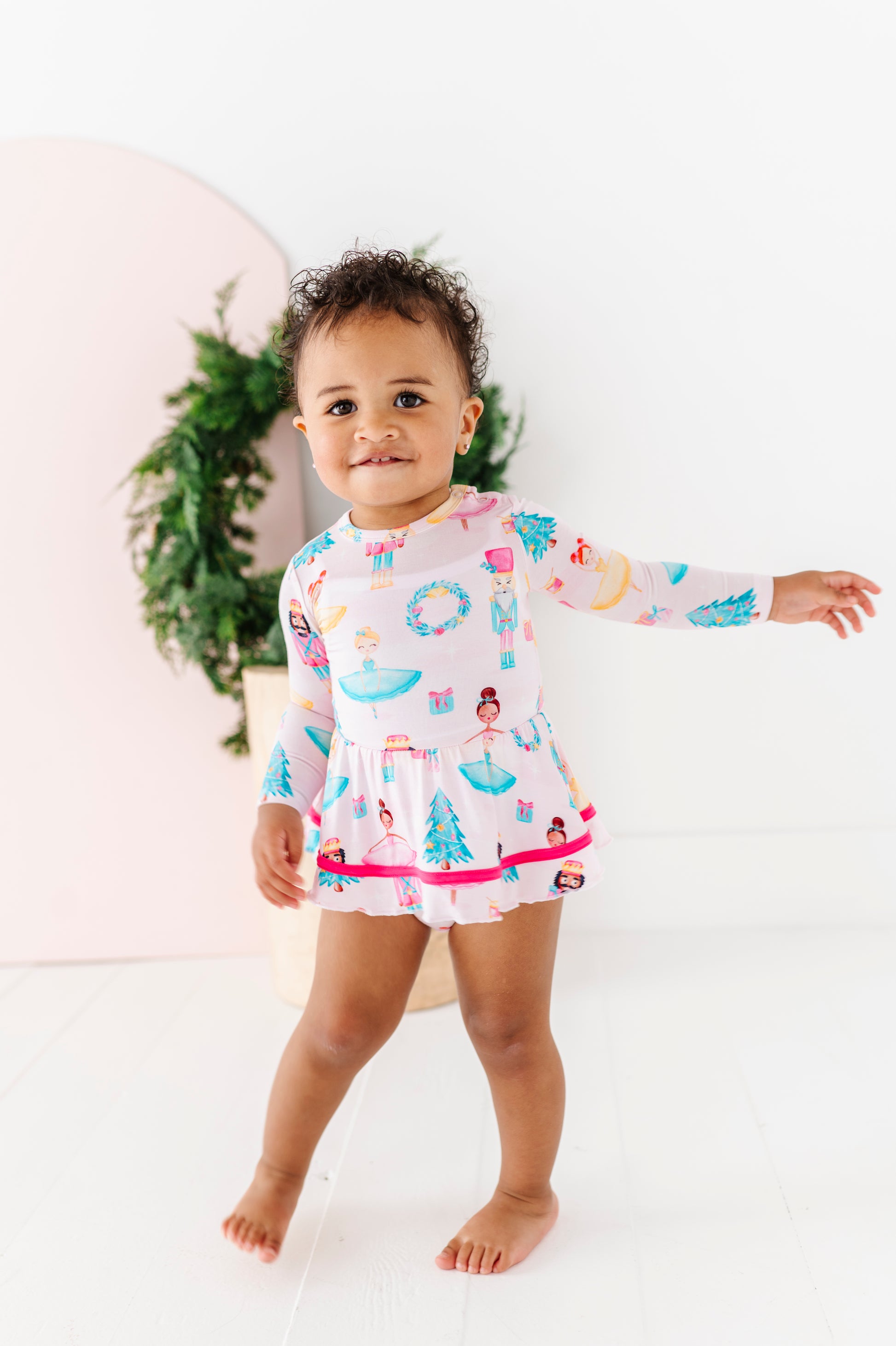 Infant wearing Sugarplum Birdie Twirl bamboo dress with Nutcracker holiday print