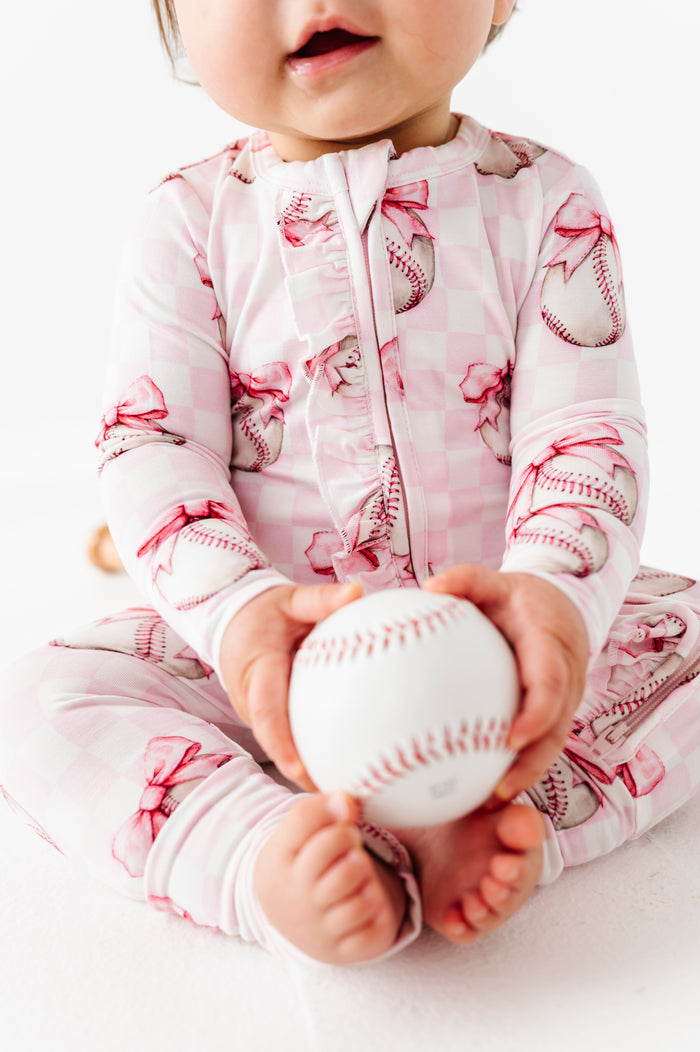 Baby holding a baseball wearing bamboo pajamas