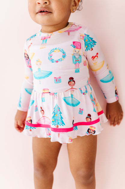 Child wearing a long-sleeve Sugarplum bamboo dress