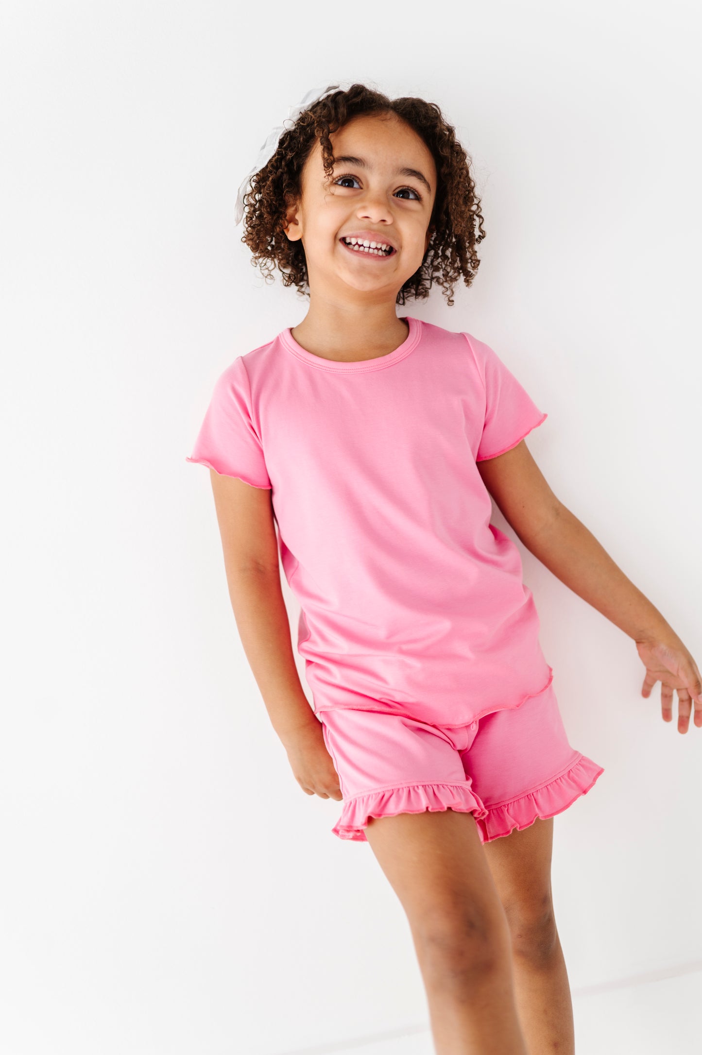 Child wearing a pink bamboo/cotton outfit on a white background