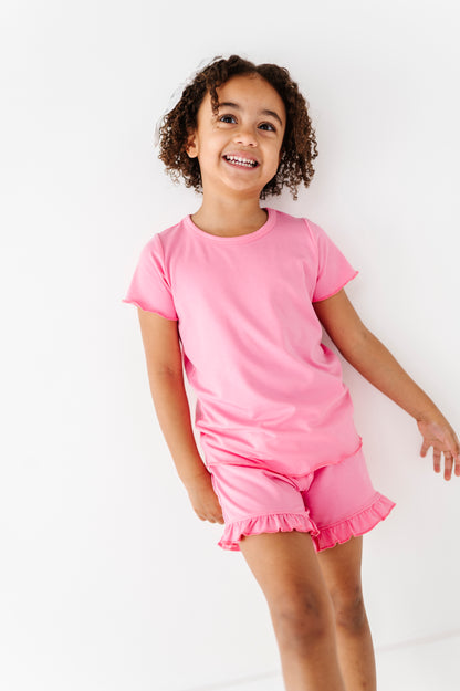 Child wearing a pink bamboo/cotton outfit on a white background