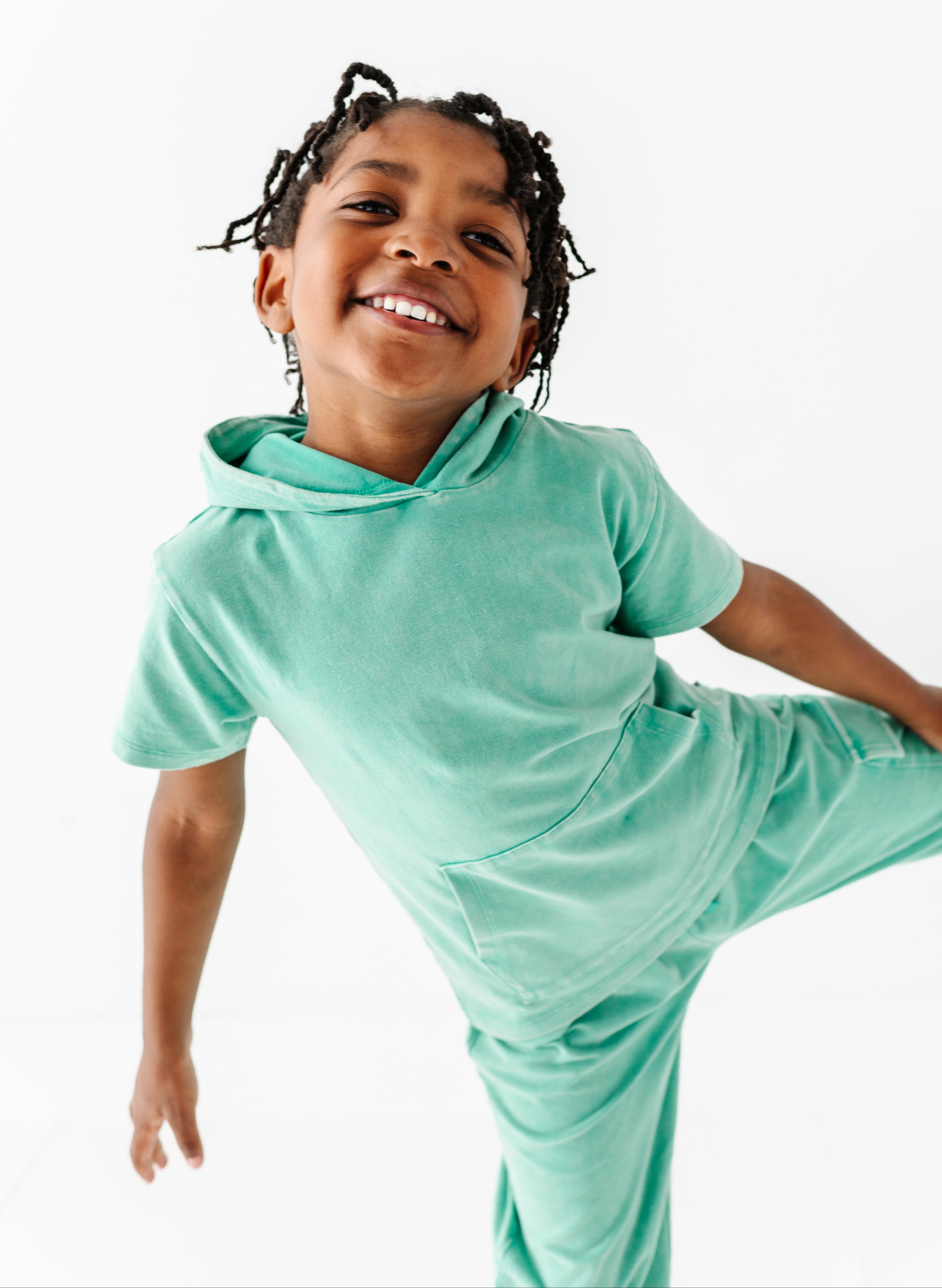 Child wearing a light green outfit on a white background