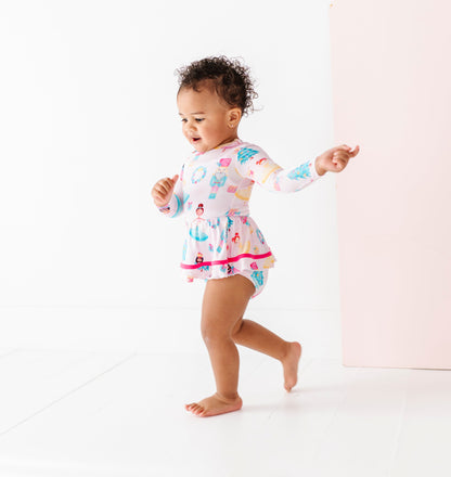 Child wearing a light pink Christmas bamboo dress with a bodysuit underneath 