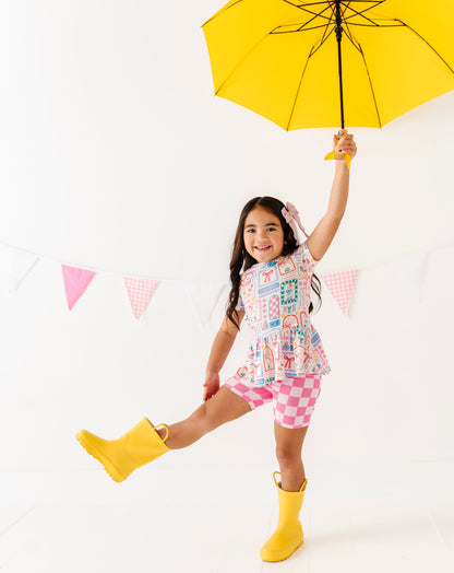 Child holding a yellow umbrella against a white background