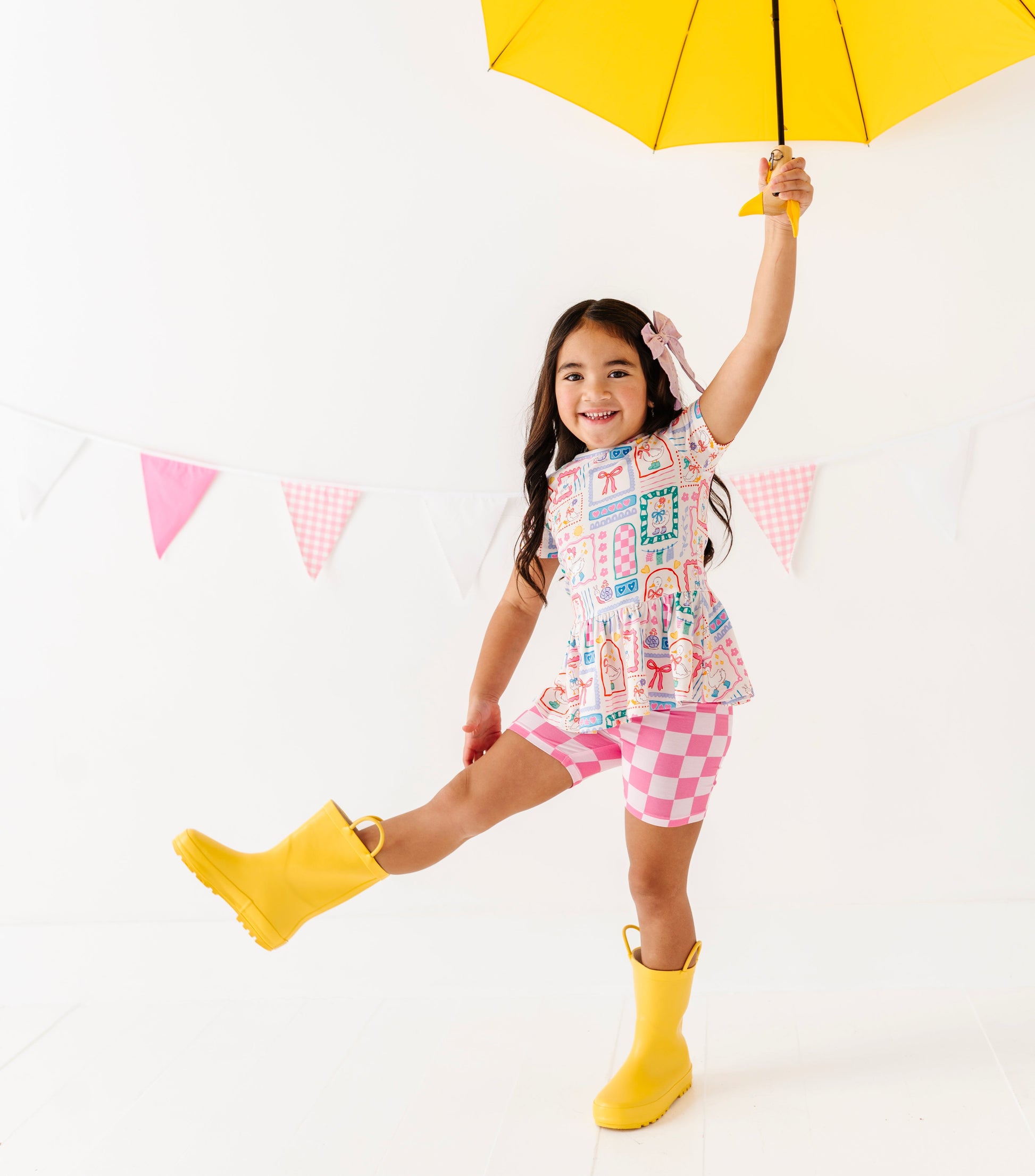 Child holding a yellow umbrella against a white background
