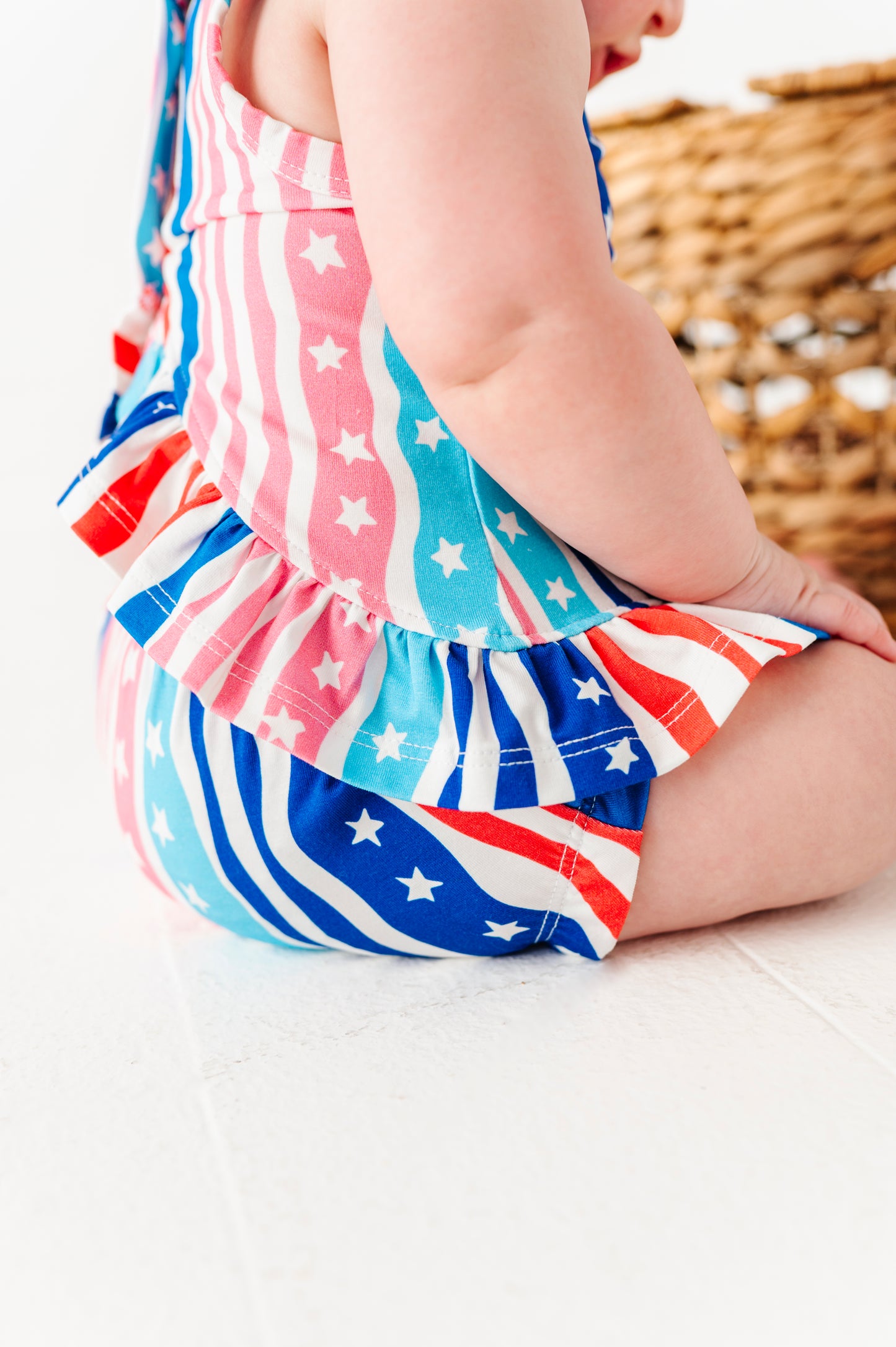 Child wearing a colorful bamboo-cotton swing top set with American flag pattern on a light background