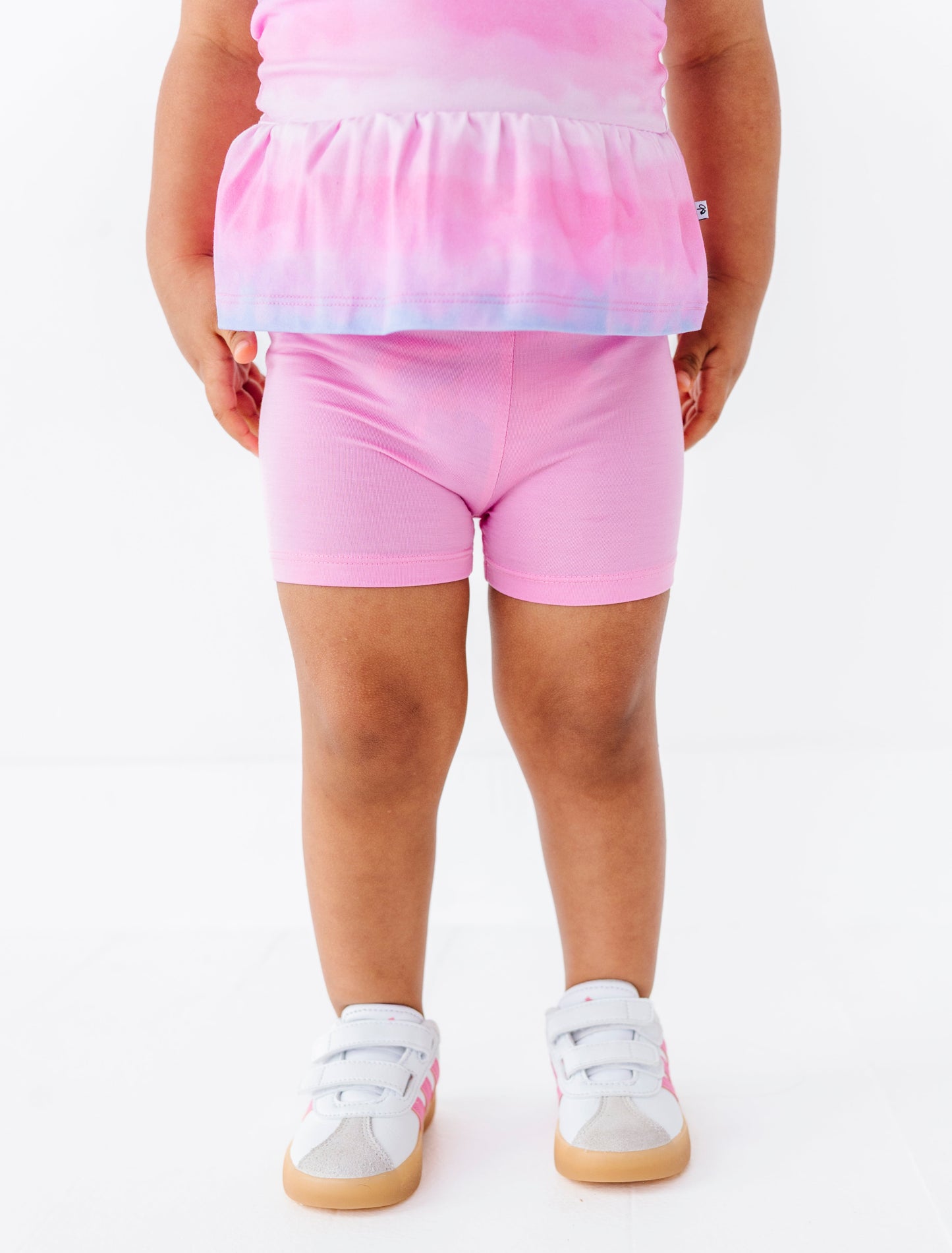 Child wearing a pink outfit with a white background