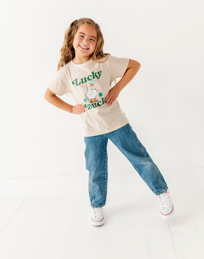 Young girl wearing a 'Lucky' t-shirt with a cartoon character on a white background