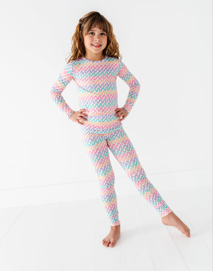 Child wearing a colorful striped bamboo pajama set on a white background