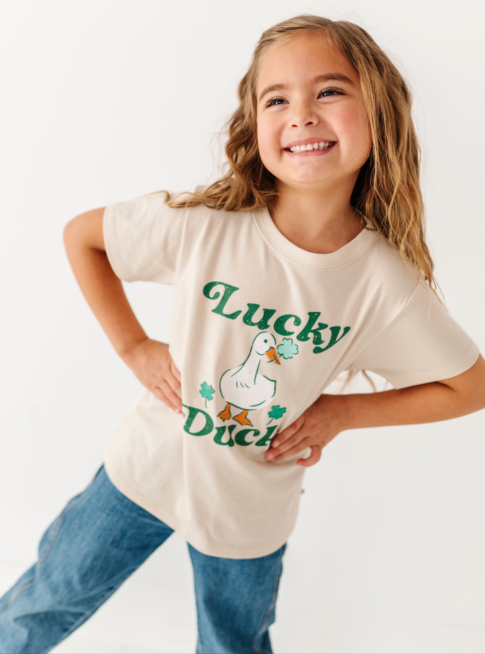 Young girl wearing a 'Lucky Duck' t-shirt on a white background