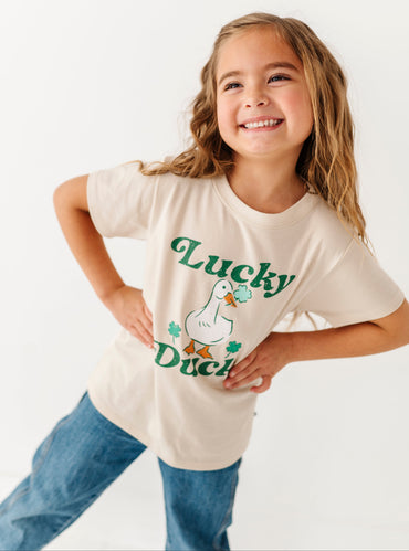 Young girl wearing a 'Lucky Duck' t-shirt on a white background