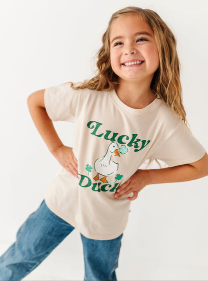 Young girl wearing a 'Lucky Duck' t-shirt on a white background