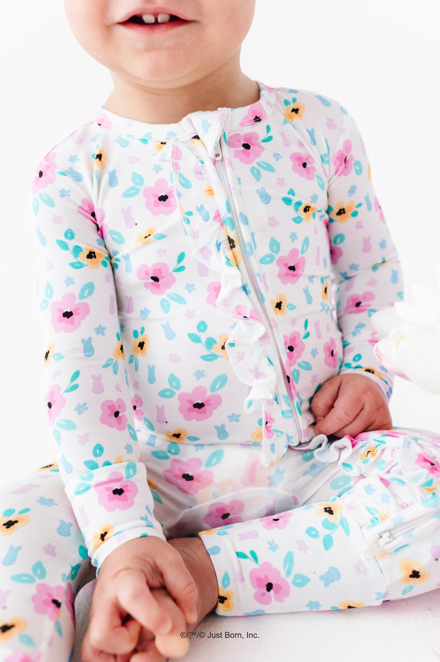 Baby wearing a floral PEEPS® bamboo romper on a white background