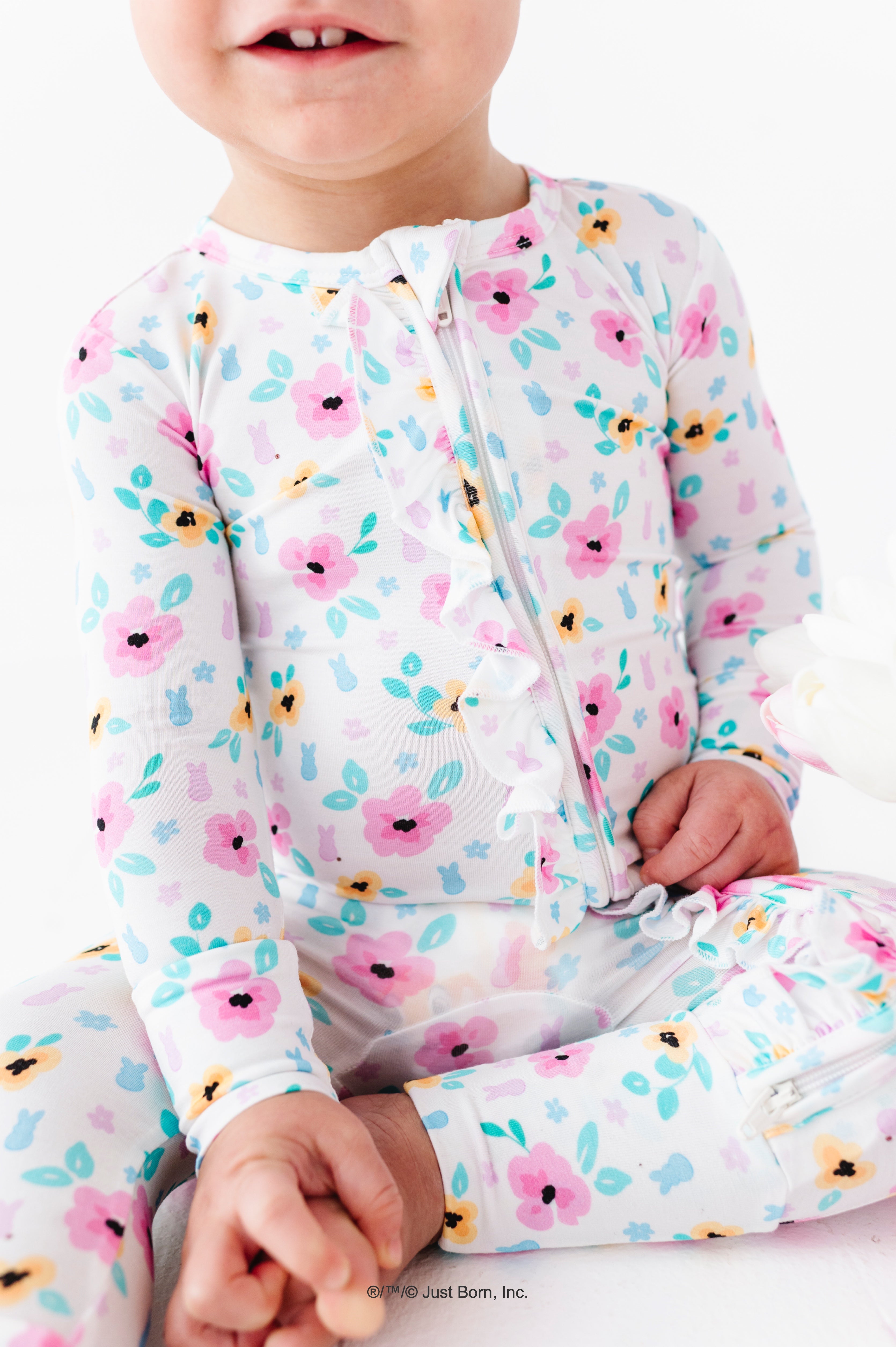 Baby wearing a floral PEEPS® bamboo romper on a white background
