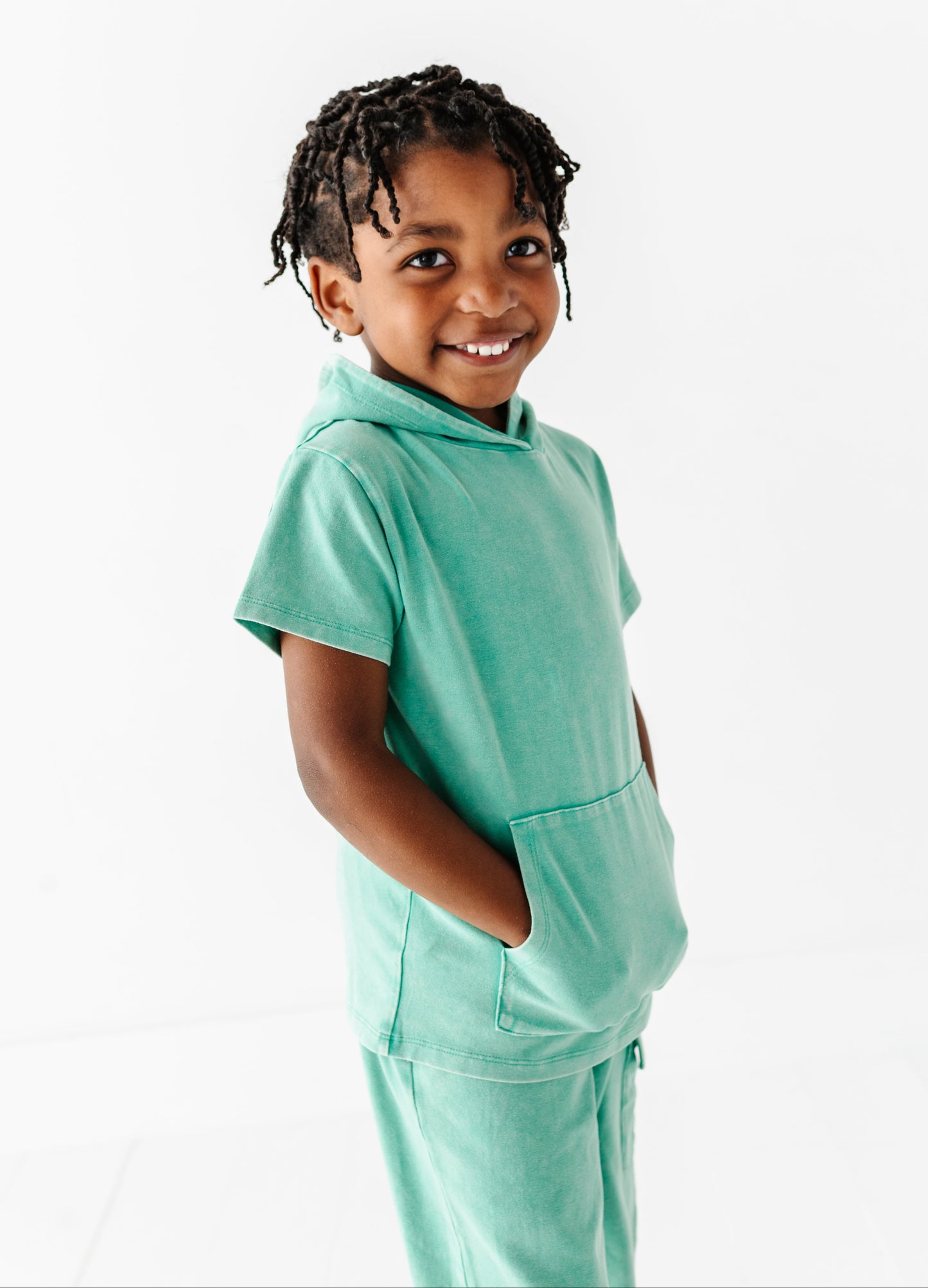 Child wearing a light green outfit on a white background