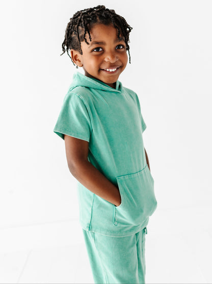 Child wearing a light green outfit on a white background