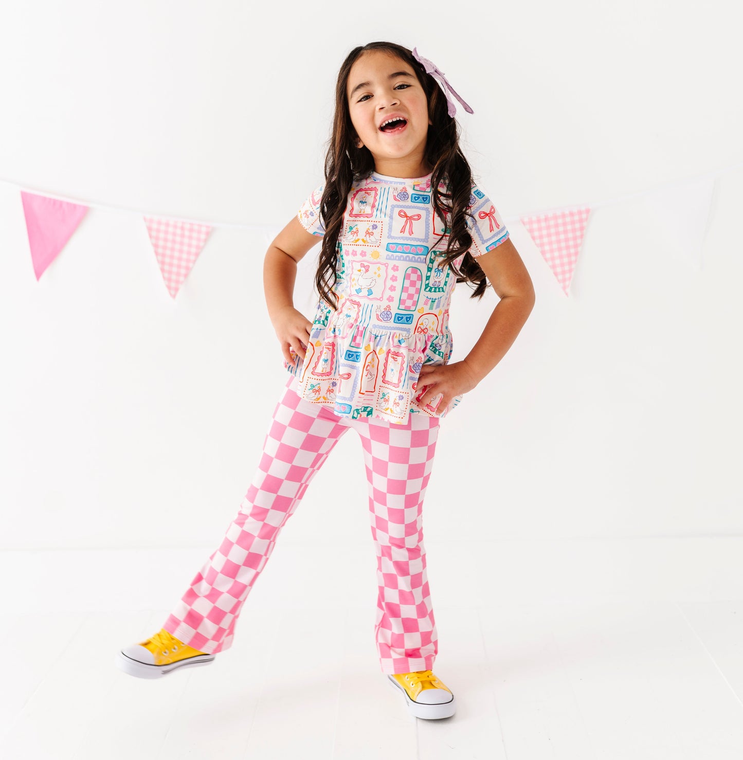 Child wearing a colorful bamboo cotton blend outfit with checkered pants on a white background