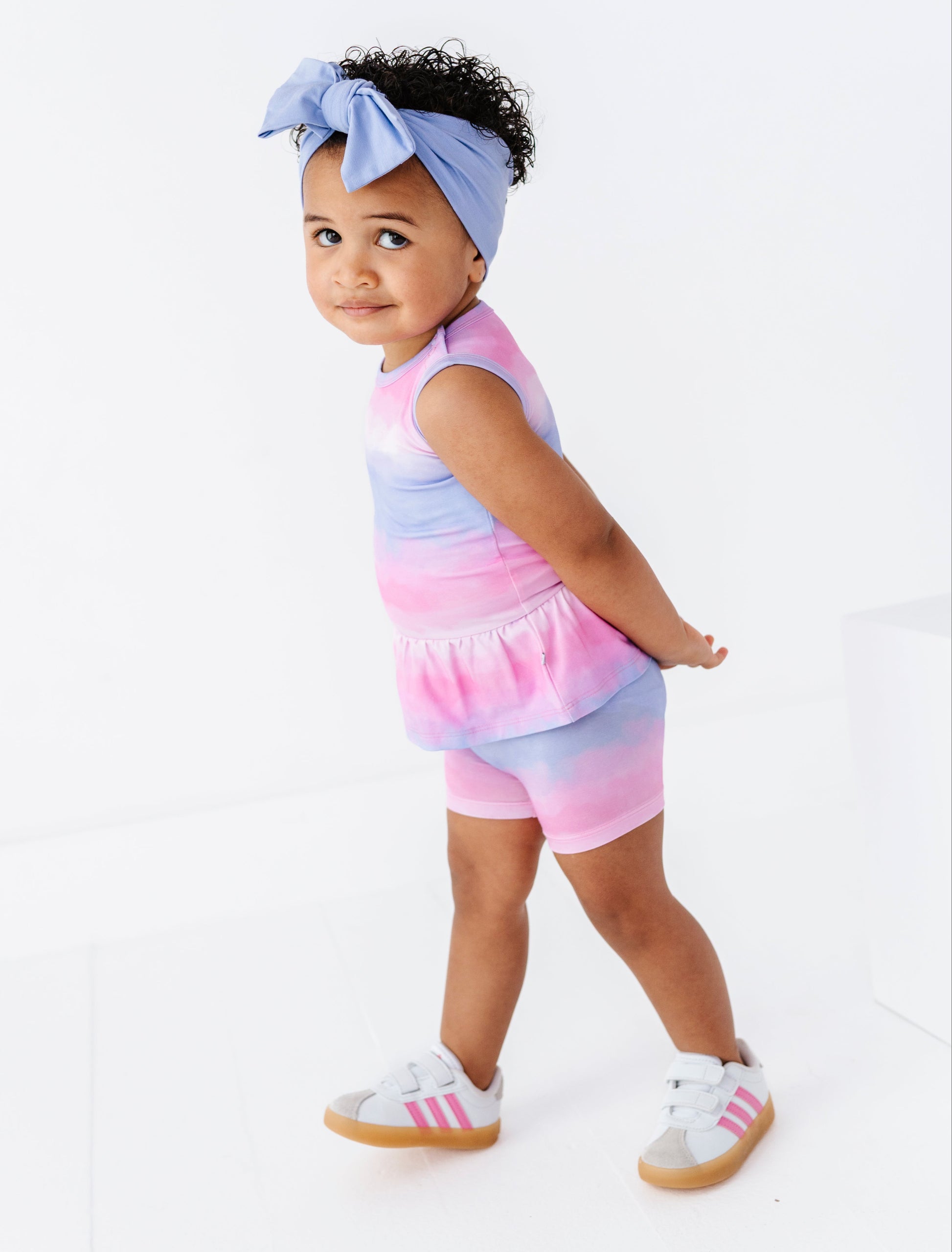 Child wearing a colorful bamboo outfit with a headband on a white background