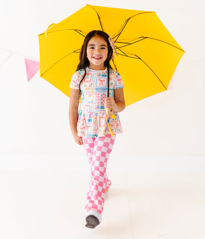 Child holding a yellow umbrella on a white background