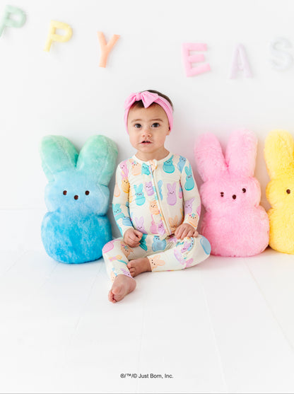 Baby in a colorful outfit sitting among pastel bunny plush toys with 'Happy Easter' text in the background.