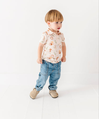 Child wearing a patterned Easter shirt and jeans on a white background