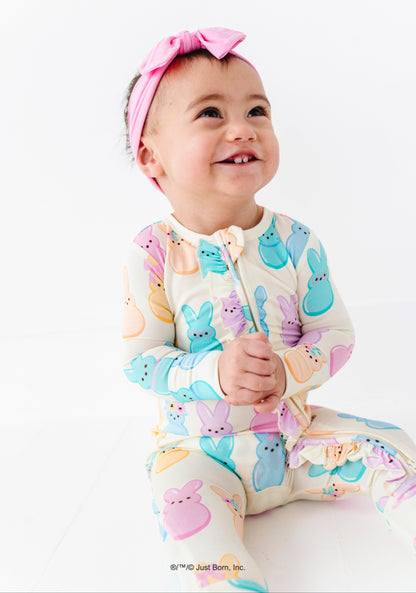 Baby wearing a colorful romper with  PEEPS® pattern on a white background