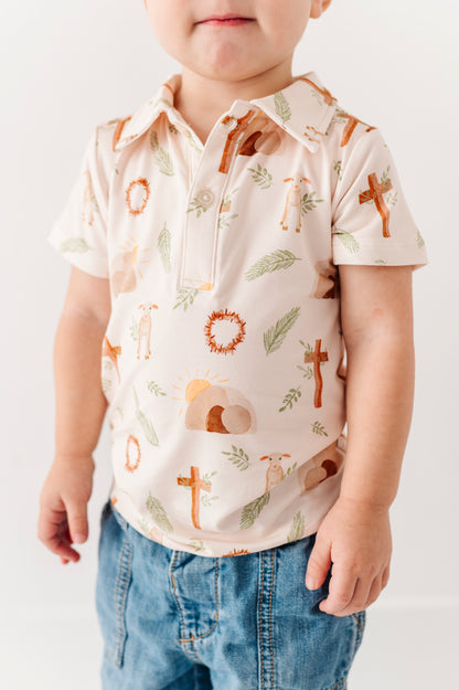 Child wearing a short-sleeve shirt with Easter-themed print and blue jeans on a white background