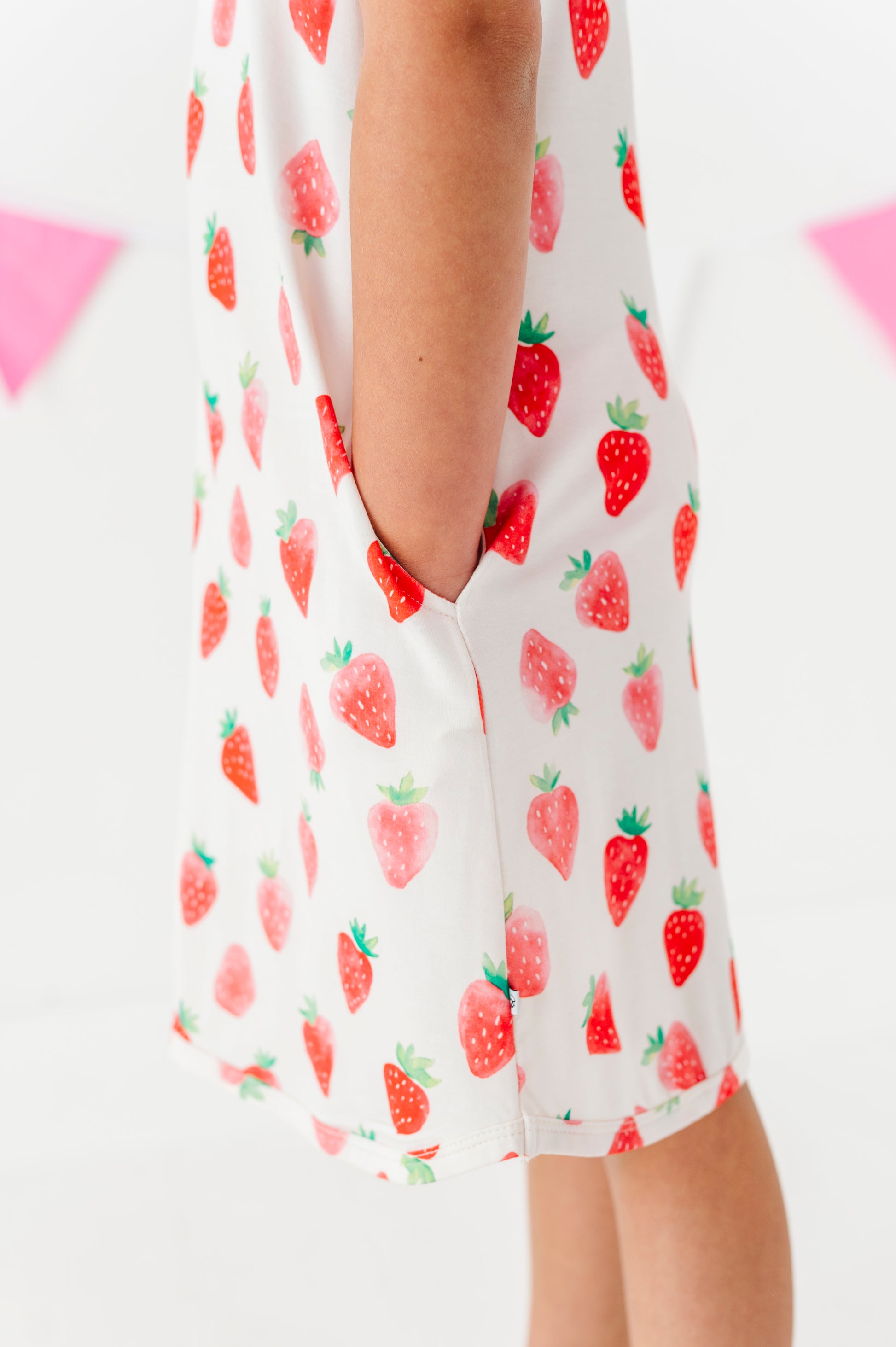 White dress with red strawberry pattern on a white background