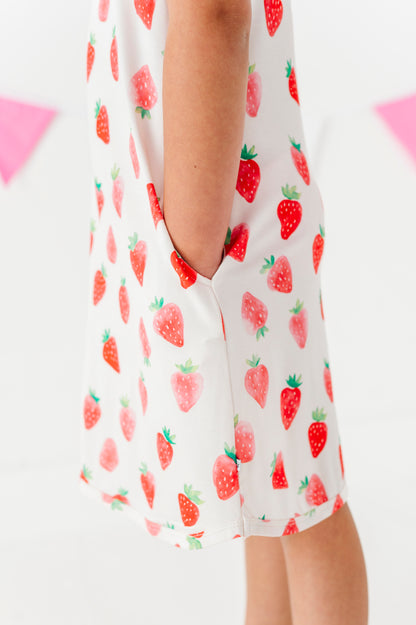 White dress with red strawberry pattern on a white background