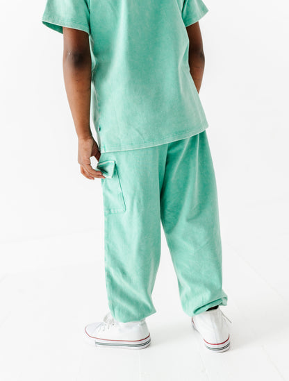 Child wearing a mint green outfit on a white background