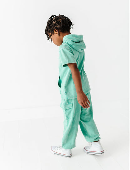 Child wearing a mint green outfit on a white background