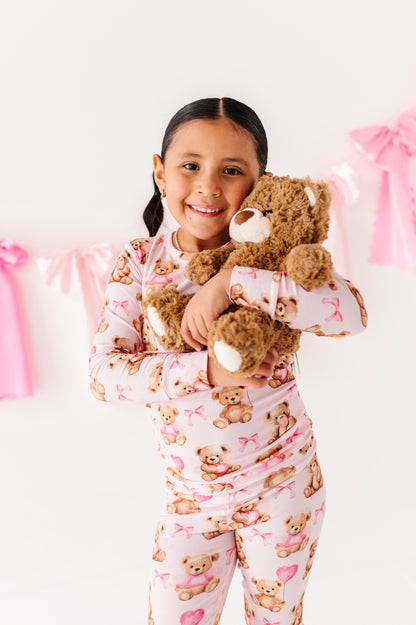 Child in Pink Beary Sweet bamboo two-piece pajamas holding a plush teddy bear