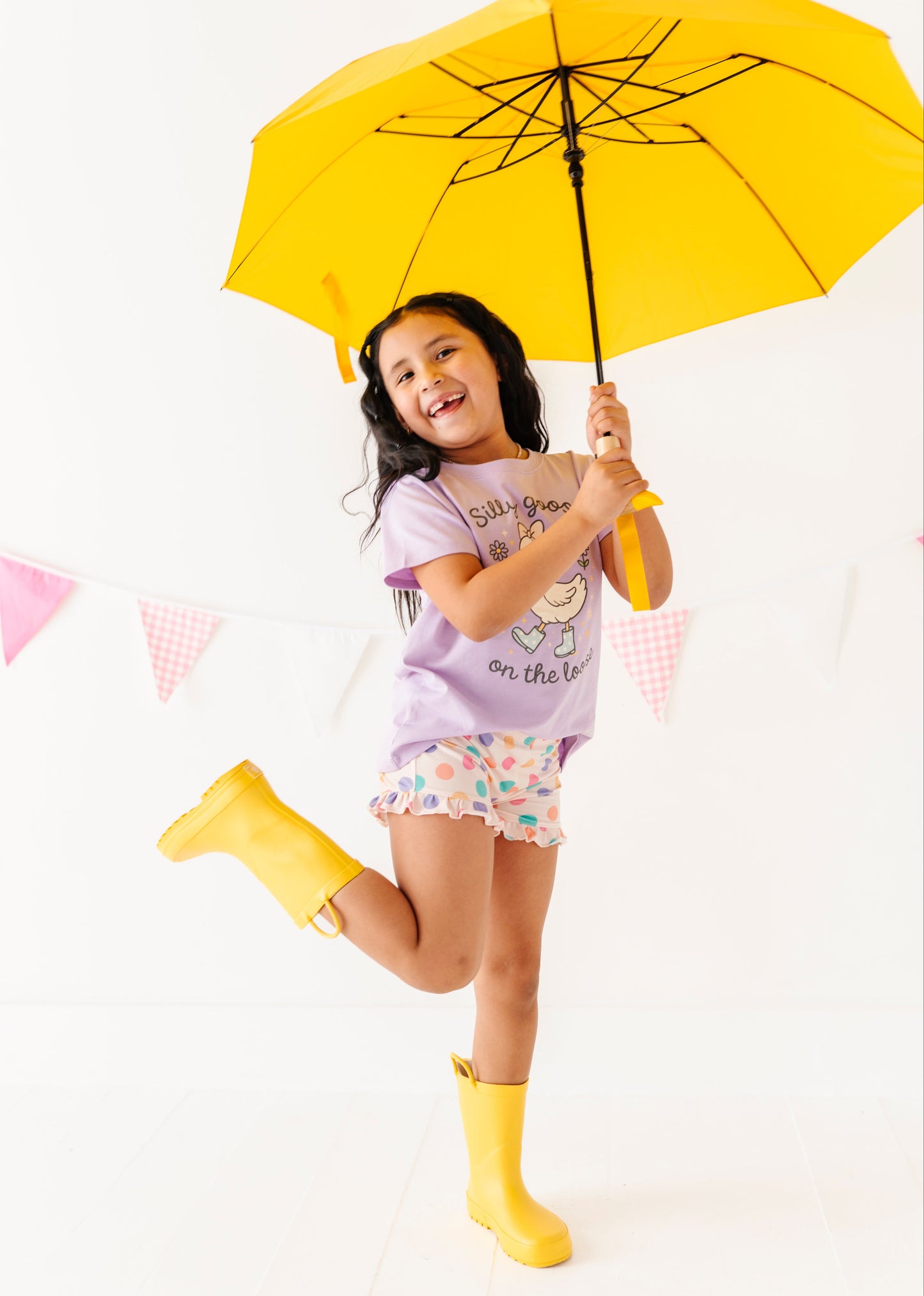 Child holding a yellow umbrella on a white background