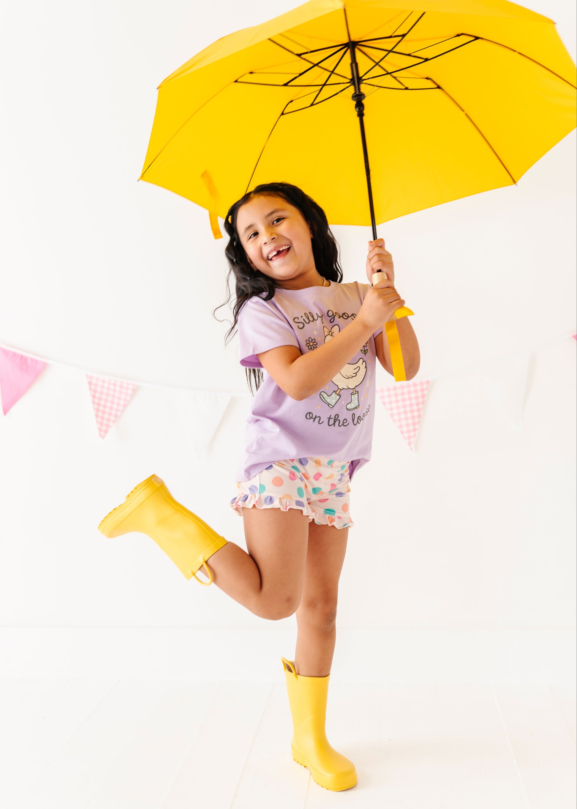 Child holding a yellow umbrella on a white background