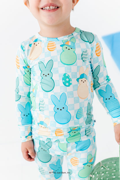 Child wearing a Peeps-themed pajama set with colorful characters on a light blue background.