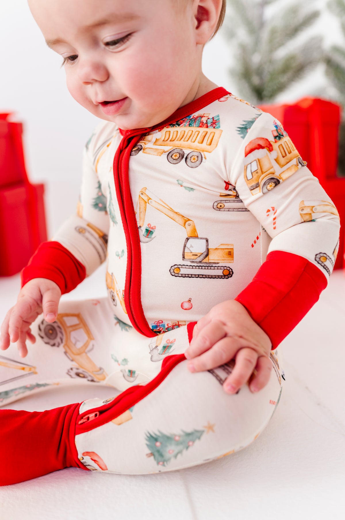 A close-up detail shot of a Christmas construction-themed bamboo zip romper