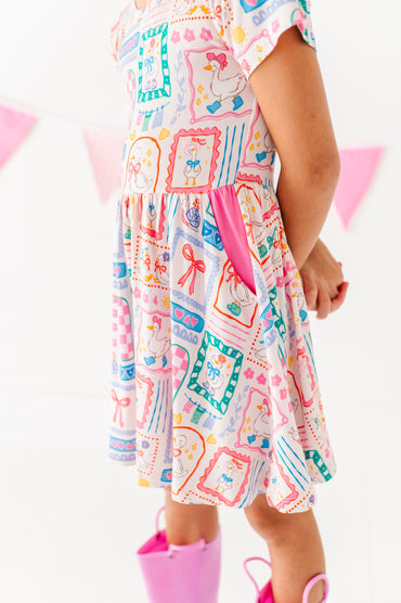 Child wearing a colorful bamboo dress with a quilted pattern on a white background