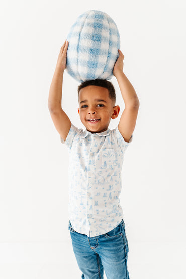 Child holding a checkered easter egg above their head against a white background