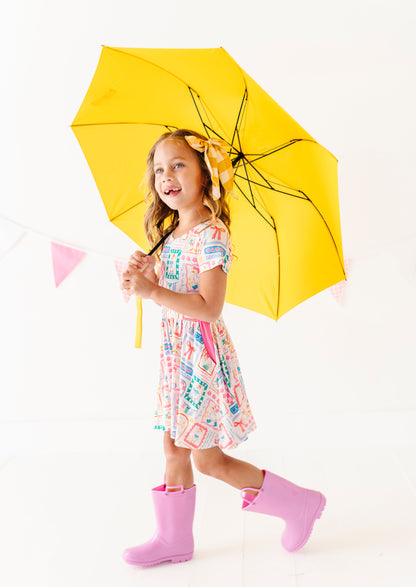 Child holding a yellow umbrella on a white background