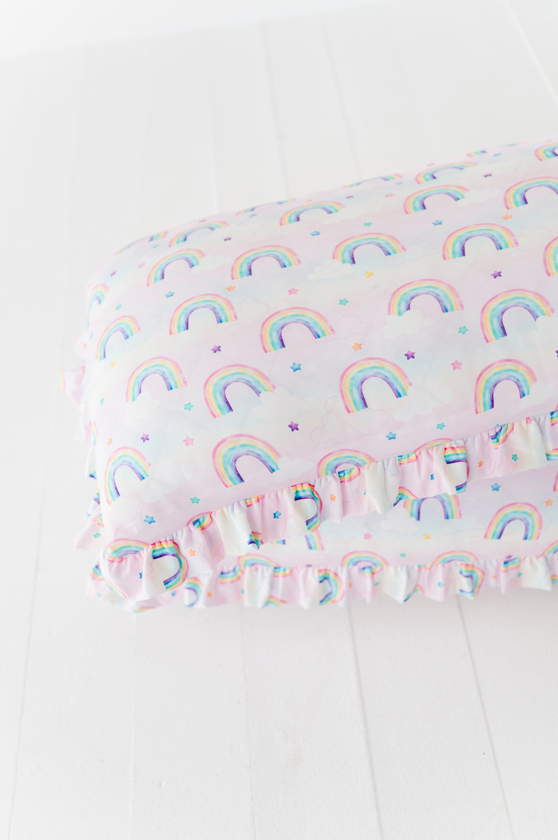 Two Rainbow Skies ruffle zipper pillowcases in a pastel rainbow and star print 