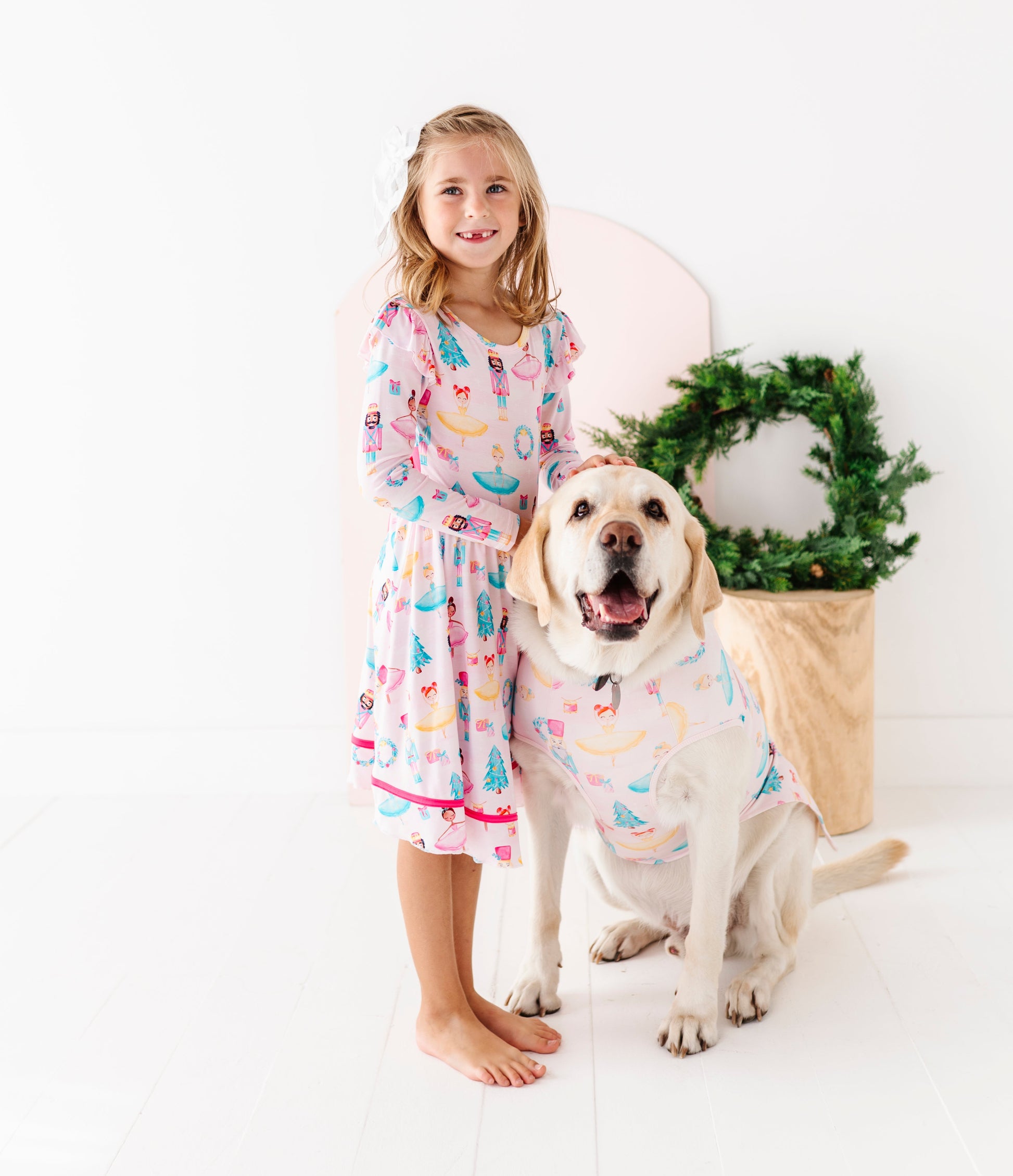 Girl and dog wearing matching bamboo Christmas clothes featuring Sugarplum fairies 