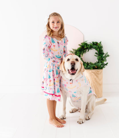 Girl and dog wearing matching bamboo Christmas clothes featuring Sugarplum fairies 