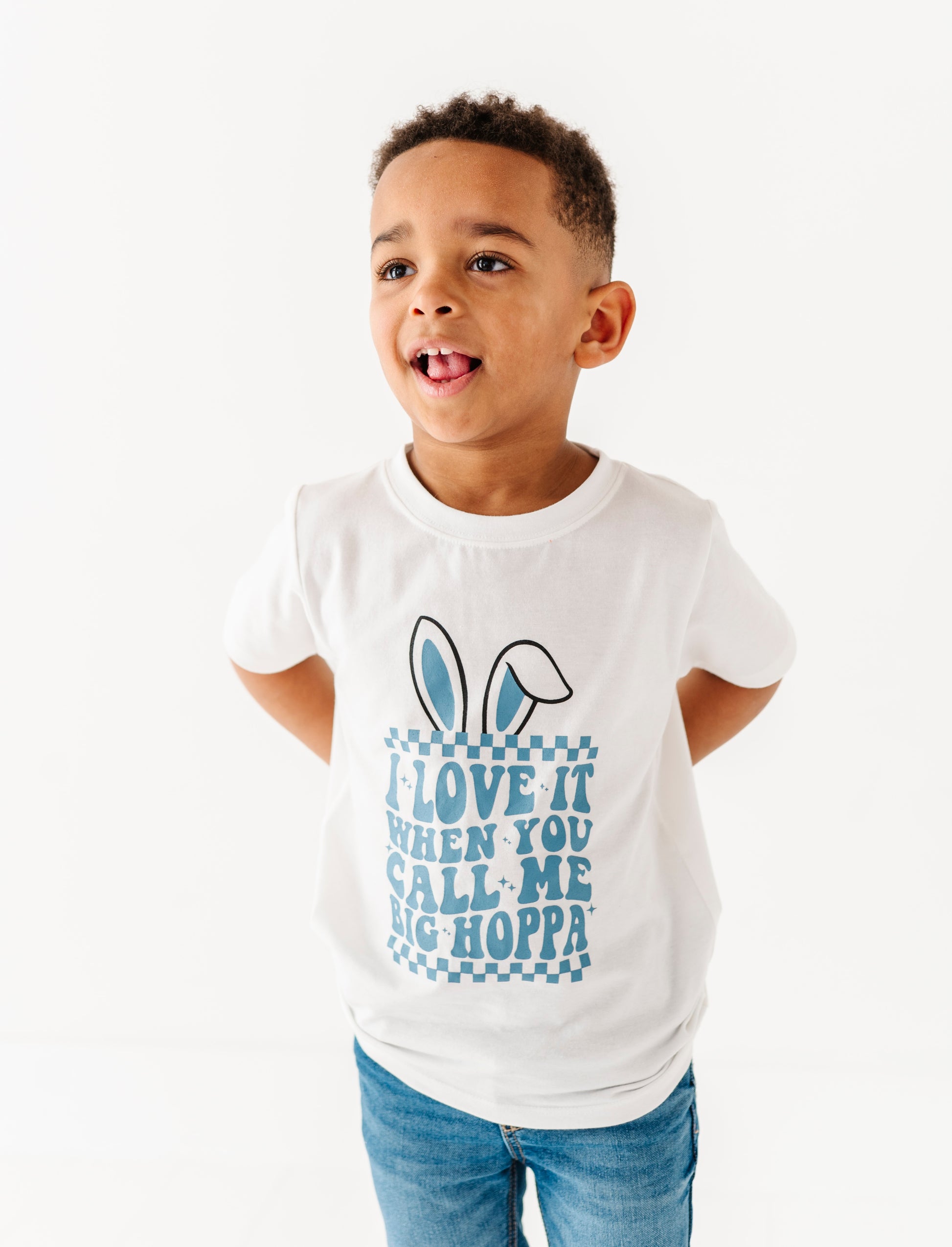 Child wearing a white t-shirt with bunny ears and text on a white background