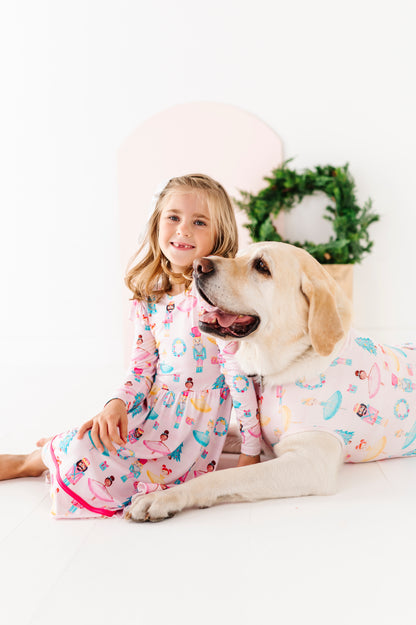 Girl and dog wearing matching bamboo Christmas outfits on a white background